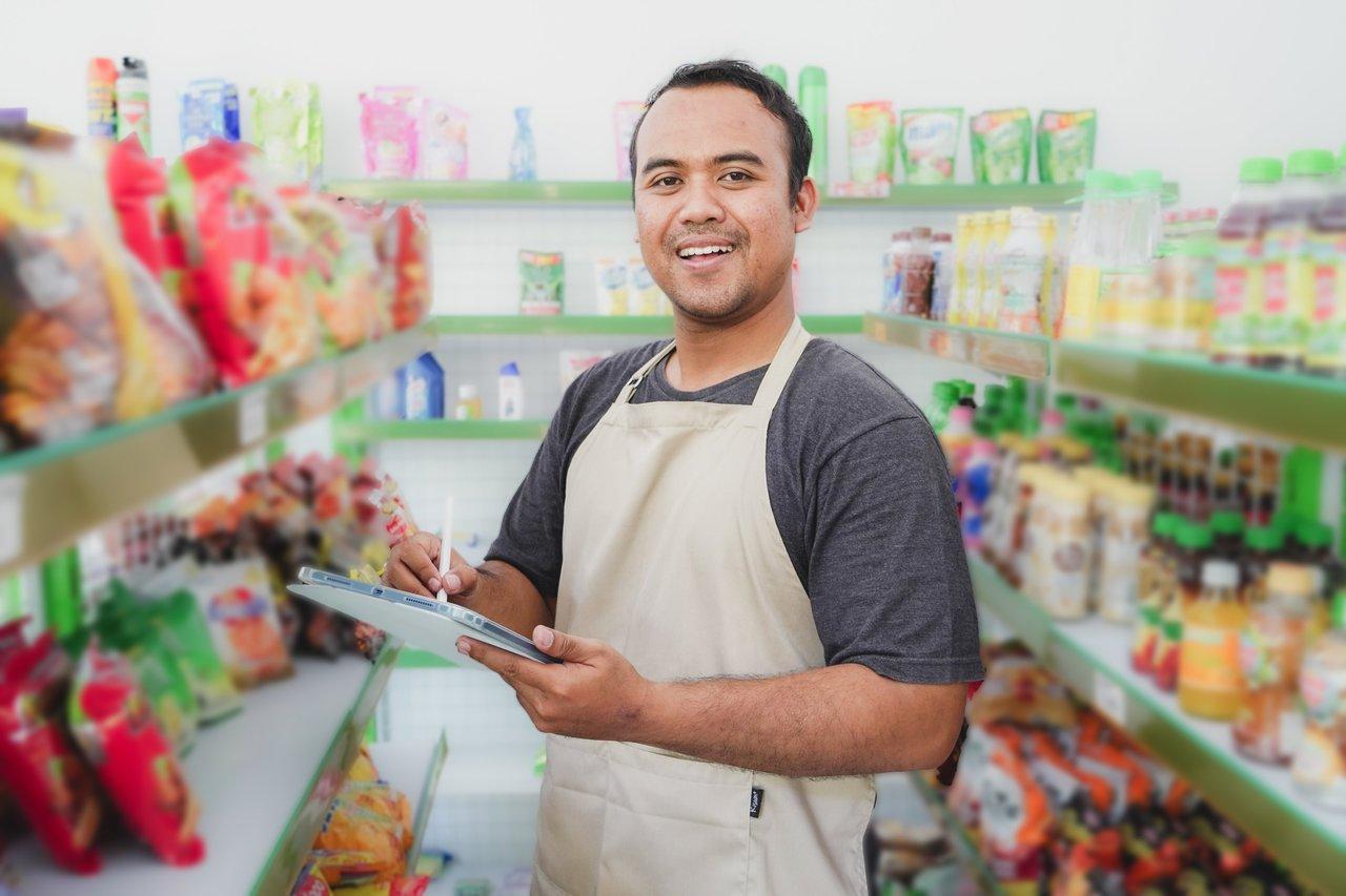 Vendeur équipé d'une tablette pour une assistance client connectée en magasin retail.